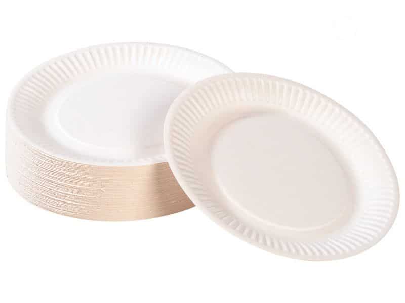 Une pile d'assiettes jetables blanches GRAND PACK TRAITEUR, dont l'une est dressée pour mettre en valeur son bord strié et son design simple - idéal pour l'organisation parfaite d'un buffet avec coupe de champagne.