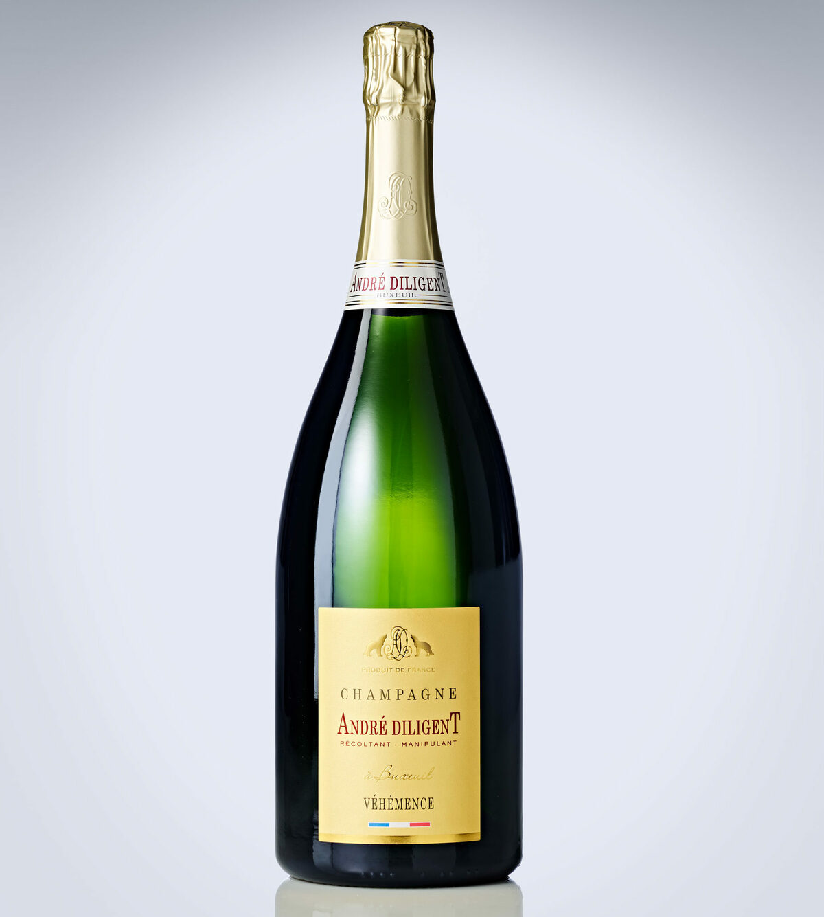 Une bouteille de CHAMPAGNE ANDRÉ DILIGENT (Brut Blanc 75cl) avec un bouchon et une étiquette en feuille d'or, sur un fond de dégradé clair. L'étiquette porte les mentions "Champagne André Diligent" et "Véhémence".
