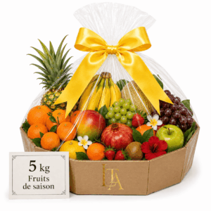 Un panier cadeau « CORBEILLE DE FRUITS DE SAISON » de 5 kg, composé d'un assortiment de fruits tels que des ananas, des oranges, des bananes, des raisins et des pommes, joliment emballé dans du film plastique transparent et orné d'un ruban jaune.
