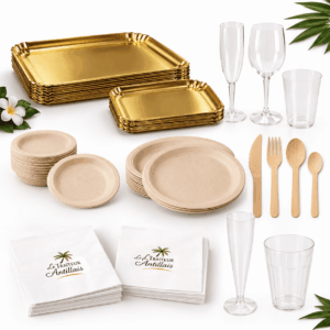 Le « PETIT PACK TRAITEUR ECO RESPONSABLE », composé d’assiettes jetables dorées et beiges, de couverts en bois, de verres en plastique transparent et de serviettes blanches arborant le logo du Traiteur Antillais, est joliment disposé sur un fond blanc orné de feuilles vertes et de fleurs blanches.