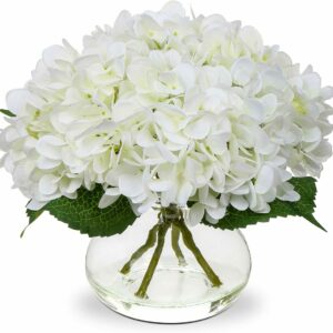 Le CENTRE DE TABLE présente des fleurs d'hortensia blanches et des feuilles vertes dans un vase rond en verre, avec des tiges visibles pour un aspect propre et élégant.