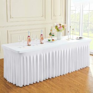 Une NAPPE BLANCHE HOUSSE RECTANGULAIRE JUPE EXTENSIBLE 60 CM L X 200 CM L recouvre une longue table garnie de bouteilles de rosé, de verres, d'un vase fleuri, de desserts et d'une assiette de fruits près d'une fenêtre lumineuse dans une pièce élégante.