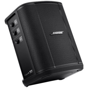 L'ENCEINTE BOSE S1 (auto alimentée) est une enceinte portable noire avec une façade grillagée, des boutons de commande sur le côté gauche et le logo Bose sur la grille avant. Elle est inclinée de manière à montrer ses panneaux avant et latéraux.