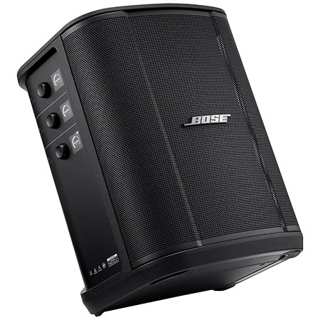 L'ENCEINTE BOSE S1 (auto alimentée) est une enceinte portable noire avec une façade grillagée, des boutons de commande sur le côté gauche et le logo Bose sur la grille avant. Elle est inclinée de manière à montrer ses panneaux avant et latéraux.