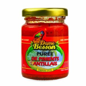 Un pot de 90 grammes de PIMENT ANTILLAIS, une purée de piment très épicée des Caraïbes avec une étiquette rouge, un couvercle doré et un logo illustré, fabriquée depuis 1970.