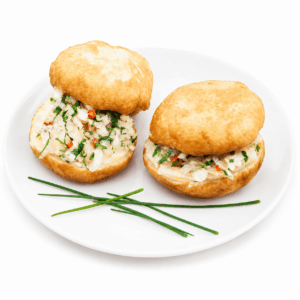 Deux MINI BOKIT GARNI MORUE sont disposés sur une assiette blanche, accompagnés de trois brins de ciboulette disposés de manière décorative à côté.