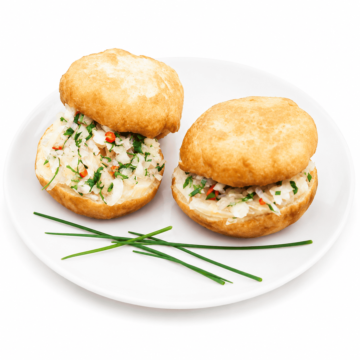 Deux MINI BOKIT GARNI MORUE sont disposés sur une assiette blanche, accompagnés de trois brins de ciboulette disposés de manière décorative à côté.