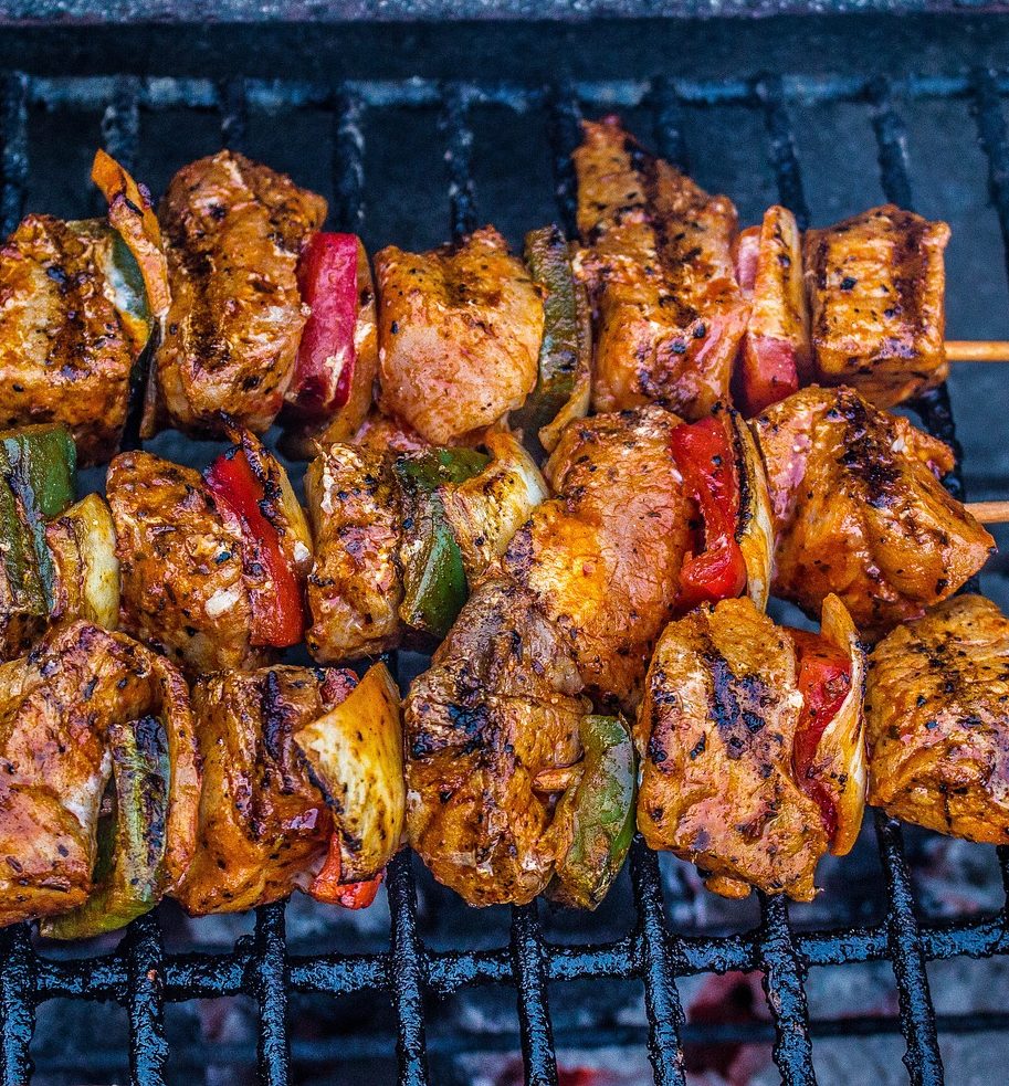 NOS VIANDES POUR L'ANIMATION BARBECUE (prix par pers) propose des brochettes de viande assaisonnée, juteuse et carbonisée, accompagnée de poivrons verts et rouges et d'oignons, grillés à la flamme nue pour une expérience barbecue savoureuse.