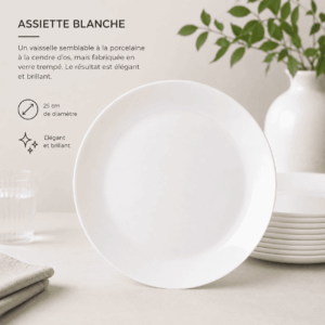 Une assiette « GRANDE ASSIETTE BLANCHE » de 25 cm est présentée à la verticale sur un fond beige, entourée d’assiettes empilées, d’une serviette et d’une plante à feuilles vertes en arrière-plan. Un texte en français décrivant les caractéristiques de l’assiette figure à gauche.