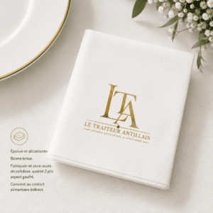 Une serviette blanche « Traiteur Cocktail » (20 x 20, lot de 50) gaufrée, arborant le logo doré « ITA Le Traiteur Antillais », repose sur une table aux côtés d’une assiette blanche et de fleurs blanches. Un texte en français met en avant le pouvoir absorbant de la serviette, sa grande qualité et son aptitude au contact indirect avec les aliments.