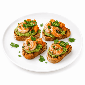 Quatre portions de TOAST DE PLANTAIN À L’AVOCAT ET AUX CREVETTES, composées d’avocat écrasé, de crevettes, de cubes de patate douce rôtis, de rondelles de piment jalapeño et de coriandre fraîche, servies sur une assiette blanche et agrémentées d’un supplément de coriandre.
