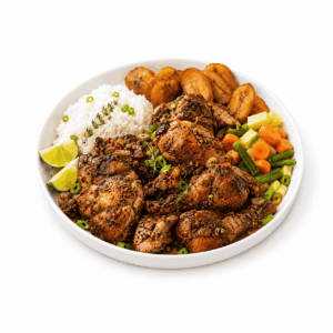Une assiette de COQ ROUSSI (commande minimum : 5 portions - 300 g par portion) servie avec du riz blanc, des bananes plantains frites, un mélange de légumes cuits à la vapeur, des quartiers de citron vert, et agrémentée d'oignons verts et de thym.