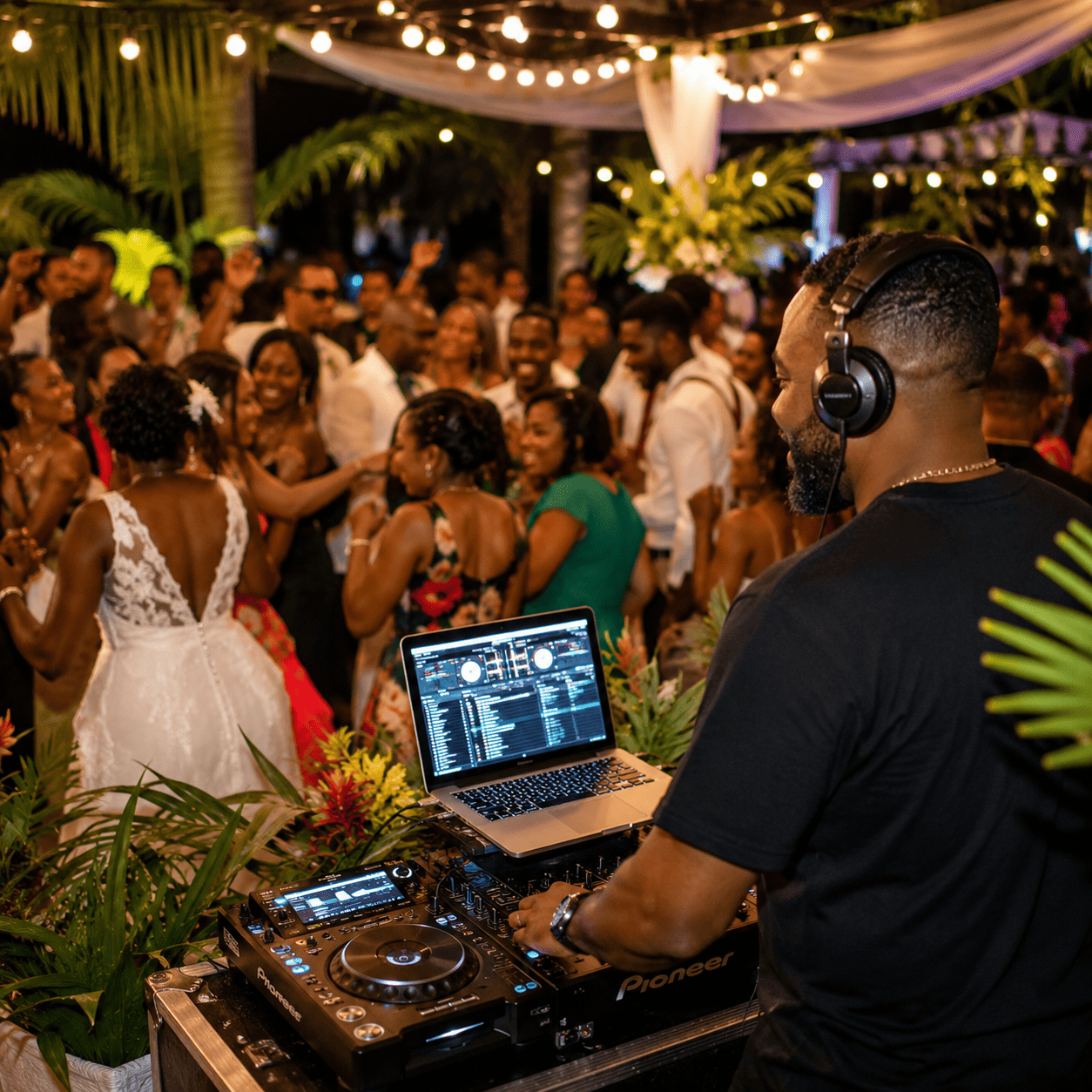 Un DJ professionnel (7 heures de prestation) anime musicalement une réception de mariage en plein air, où les invités dansent et font la fête sous des guirlandes lumineuses tandis que la mariée, vêtue de blanc, se mêle à la foule.