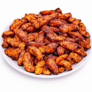 Une portion d'ALLOCO (200g/pers) présente des tranches de plantain frites, croustillantes et dorées, empilées dans une assiette blanche sur un fond blanc uni.