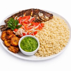 ATTIÉKÉ (Minimum de commande pour 5 pers/200g/), servi avec du poisson entier grillé, des tomates et des oignons en tranches, des bananes plantains frites, du couscous, de la sauce verte et du persil sur fond blanc.