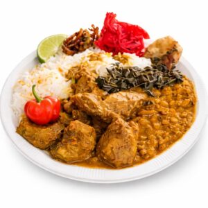 COLOMBO DE CABRI (Minimum de commande 5 parts - 300g la part) : un plat servi sur assiette blanche avec cabri, lentilles, riz blanc, légumes verts, item frit, gingembre mariné, citron vert, garniture croustillante et piment rouge.