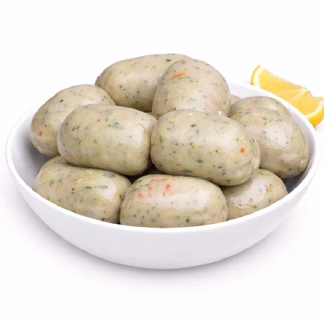 Un bol blanc avec plusieurs morceaux de BOUDIN À LA MORUE (commande minimum 5, 40g chacun), mouchetés d'herbes et de légumes, servis avec un quartier de citron sur le côté.