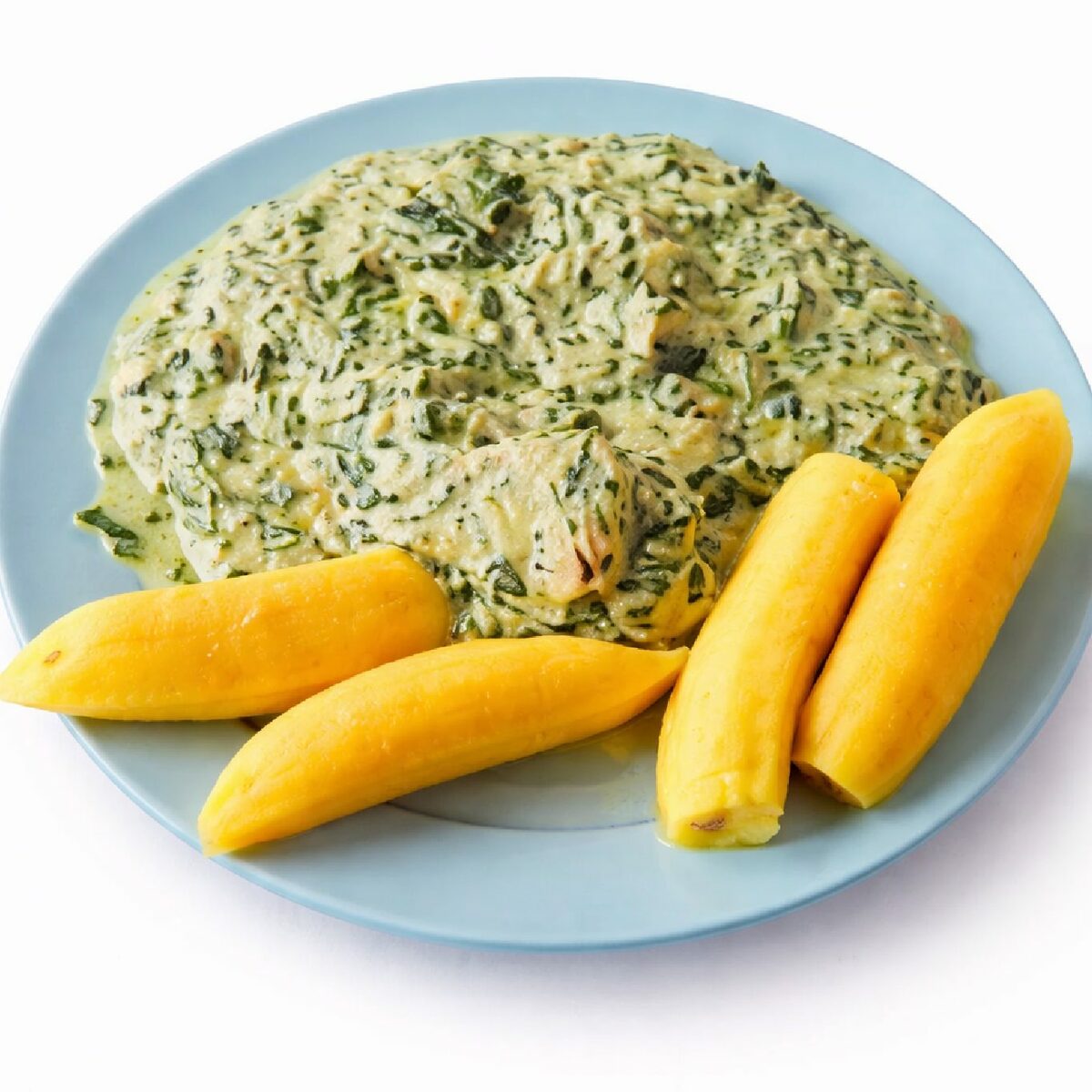 Assiette bleue avec quatre bananes plantains jaunes bouillies et NDOLÉ POULET (300g), un ragoût de légumes verts dans une sauce crémeuse, isolée sur un fond blanc.