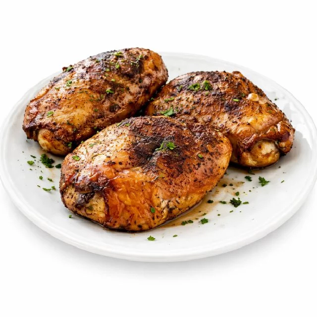 Une portion de CUISSE DE POULET BOUCANÉ 350 GR (commande minimum de 5 pièces) est présentée sur une assiette blanche, garnie d'herbes hachées sur fond blanc.