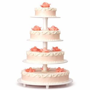 Le PIÉCE MONTÉE ROMANTICA 50 PARTS est un gâteau de mariage rose à quatre étages avec des détails de glaçage blanc et des garnitures en forme de roses sur chaque étage, présenté sur un support blanc sur un fond uni.