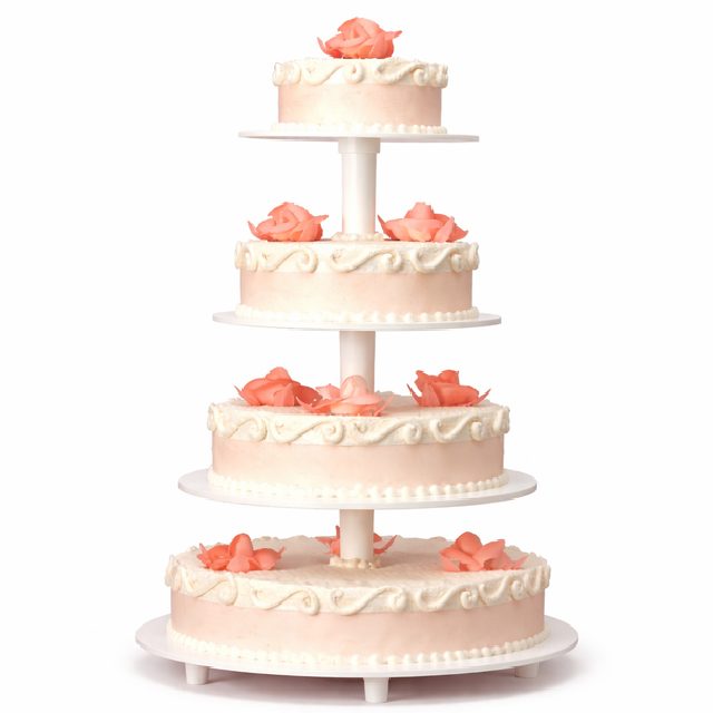 Le PIÉCE MONTÉE ROMANTICA 50 PARTS est un gâteau de mariage rose à quatre étages avec des détails de glaçage blanc et des garnitures en forme de roses sur chaque étage, présenté sur un support blanc sur un fond uni.