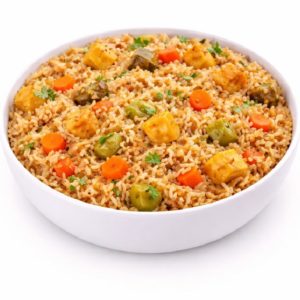 Un bol blanc rempli de RIZ CRÉOLE - riz frit mélangé à des cubes de paneer, des poivrons verts, des carottes, des petits pois, et garni d'herbes fraîches (commande minimum : 5 personnes/250g par portion).