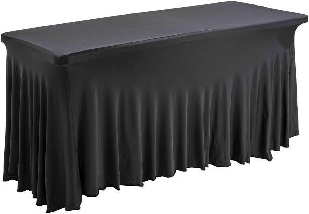 Une table rectangulaire recouverte de la NAPPE HOUSSE NOIRE RECTANGULAIRE 2m x 0,60cm, une nappe noire ajustée qui atteint le sol de tous les côtés.